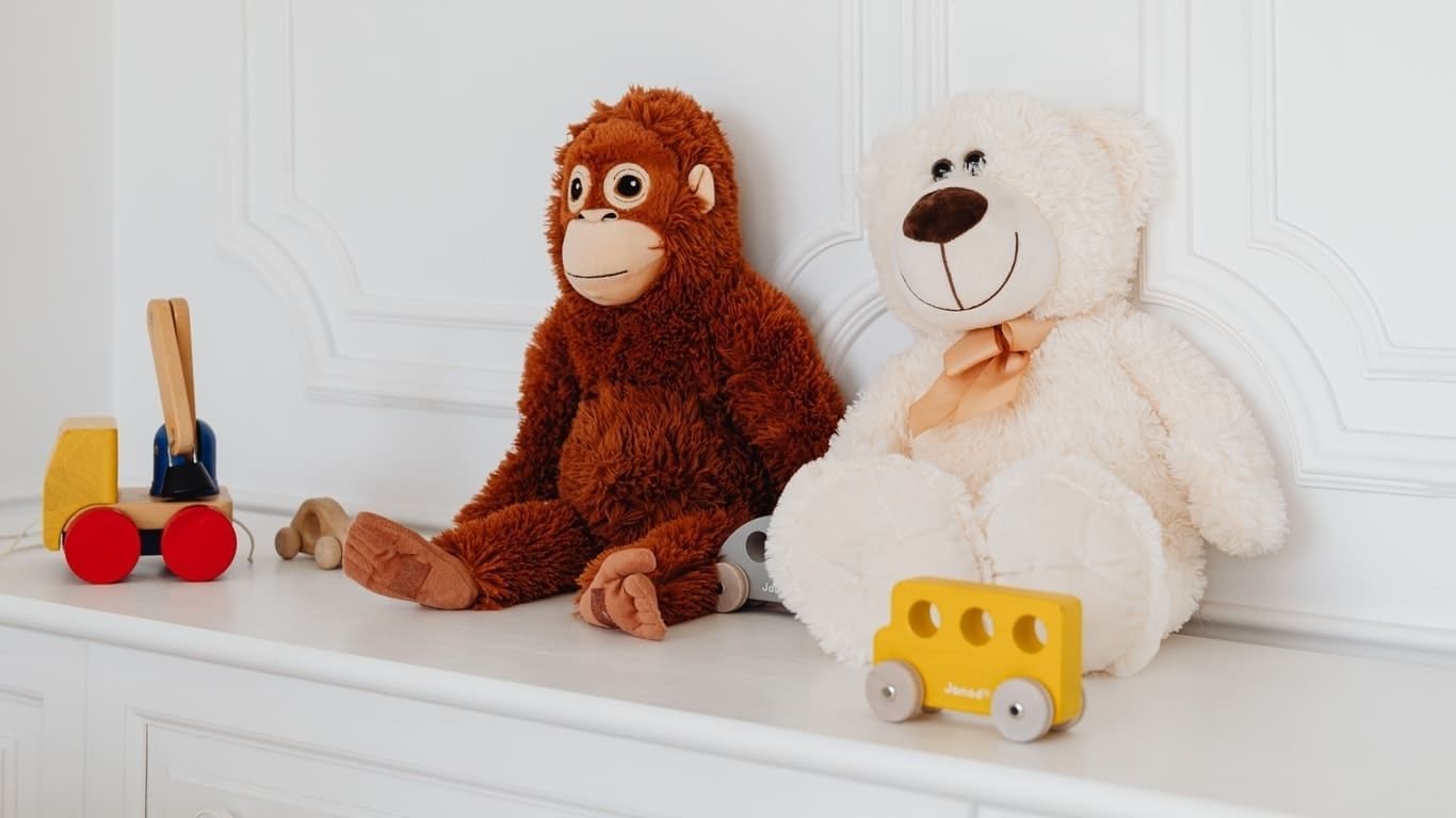 Imagem de duas pelúcias, uma é um ursinho e a outra um macaquinho