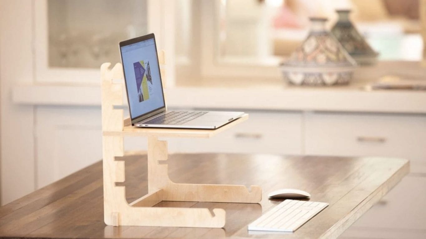 Imagem de um laptop em um suporte de madeira para melhorar a ergonomia